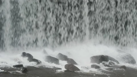 Close up of a waterfall from a dam on to the the rocks below. 4K locked tripod Stock Footage 147988827