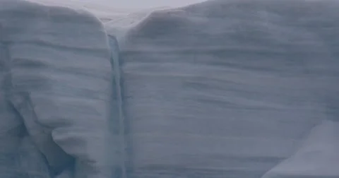 Close on waterfall flowing down glacier cliff Stock Footage 61959597