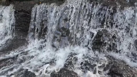 Close Up Waterfall Flowing Over Dark Rocks in 4K Stock Footage 337309211