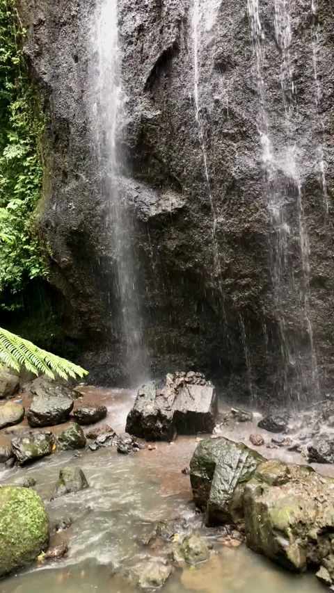 Close up waterfall flowing over mossy rocks tropical forest texture Stock Footage 332227669
