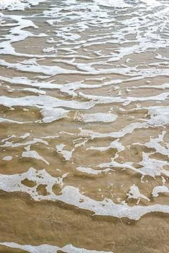 Close-up of wave on sandy beach with copy space for your text, top view backg Stock Photos