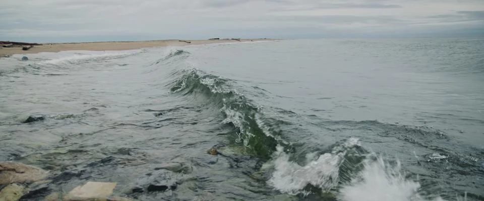 Close-up of waves and splashes. Waves splash on stones at coast beach. Strong Stock Photos