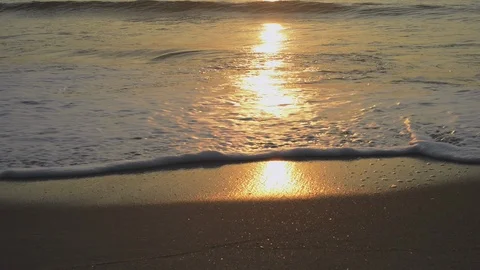 Close up of waves on beach sunset in the water downward angle Stock Footage 126662594