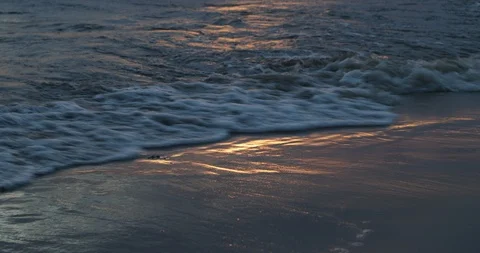 Close up of waves breaking at sandy shore at golden hour. Water movement sunset 스톡 동영상 119062216