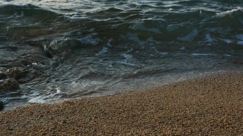 Close up of waves breaking on sea shore and washing over sand on beach Stock Footage 111401066