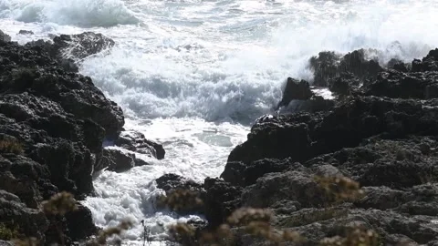 Close up on waves dashing on black rocks in a touristic resort in Puglia, Italy Stock Footage 131532395