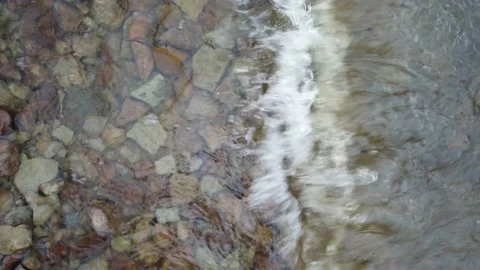 Close up of waves flowing over a rocky river bed Stock Footage 143197405