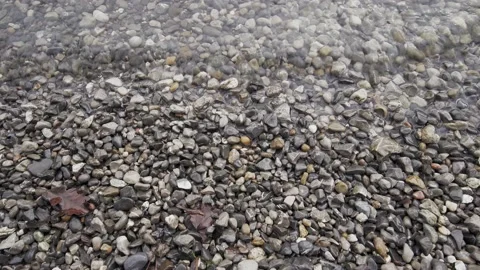 Close Up Of Waves On A Lake Shore With Thousands Of Stones Stock Footage 147130893