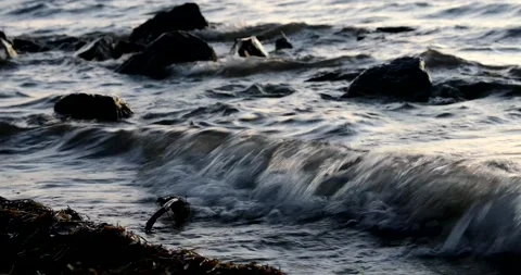 Close up of waves lapping on the rocky shore Stock Footage 211065299