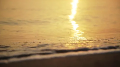 Close Up Of Waves Rolling Up The Sandy Beach at sunrise Stock Footage 75464546