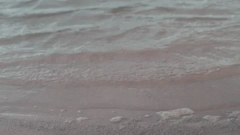 Close up of waves on the sand beach with sea foam and water ripples Stock Footage