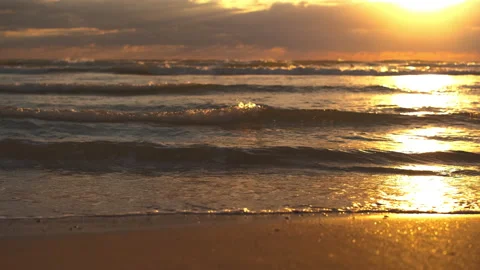 Close-up on the waves on the sandy beach, the scene of a beautiful sunset Stock Footage 208468866