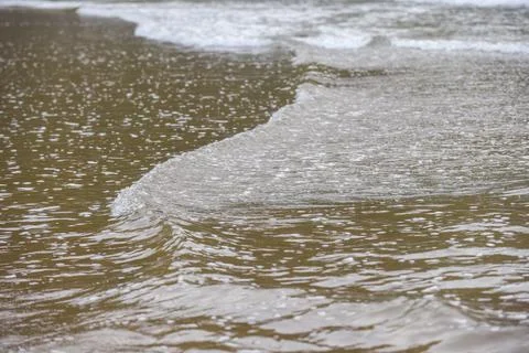 Close up of waves on the shore of a beach Stock Photos