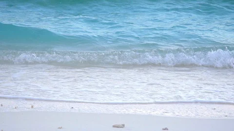 Close up of waves splashing onto a sandy white beach Stock Footage 125634454