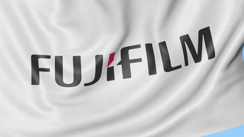 Close-up of waving flag with Fujifilm logo, seamless loop, blue background Stock Footage 72255462