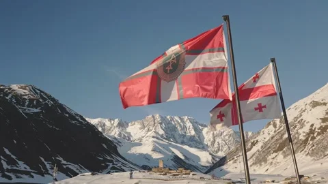 Close up of waving flags in front of Lamaria Monastery with snow-covered Ca.. Vídeos de archivo 312060961