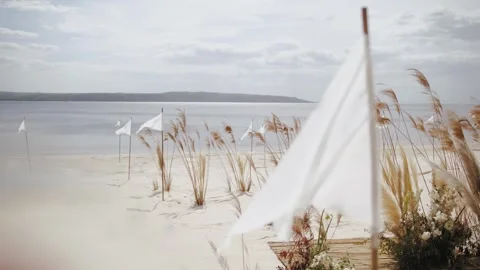 Close-up of waving white flag on the beach as a part of wedding decoration Stock Footage 308450860