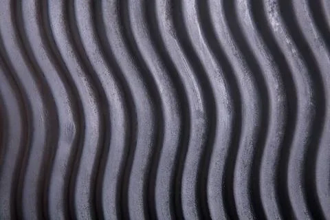 Close-up of wavy metal grating with dark and light stripes Stock Photos
