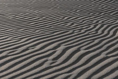 Close-up of wavy sand patterns created by the wind in a desert Stock Photos
