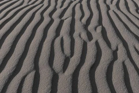 Close-up of wavy sand patterns created by the wind in a desert Stock Photos
