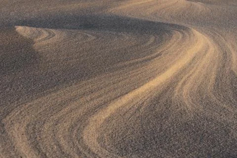 Close-up of wavy sand patterns created by the wind in a desert Stock Photos