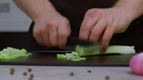 In a close-up we see the cook cutting celery. Slow motion video of cutting Stock Footage 269120996