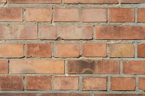 Close-up of weathered brick wall with irregular colors and textures 스톡 사진