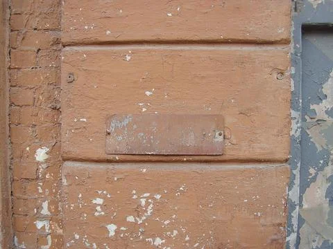 Close-up of weathered brick wall section with rusted metal grate 写真素材