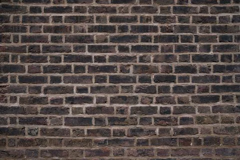 Close up of a weathered brick wall with visible texture and mortar lines in.. Stock Photos