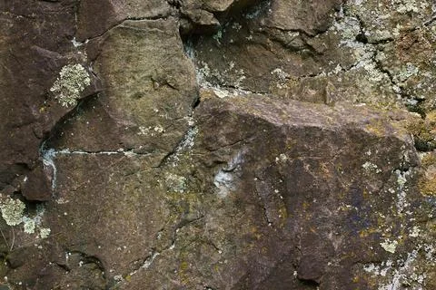 Close-Up of Weathered Brown Rock Surface with Lichen Patches Stock Photos