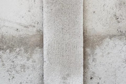 Close-up of a weathered concrete wall with a vertical pillar structure and .. Stock Photos