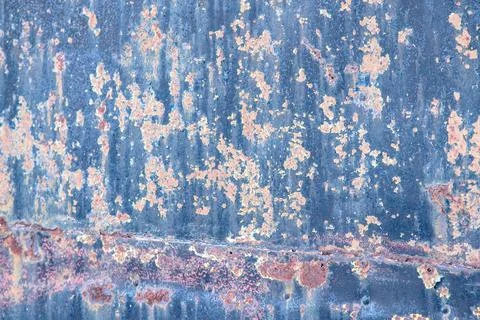 Close-up of a weathered metal surface with rust and peeling paint. Stock Photos
