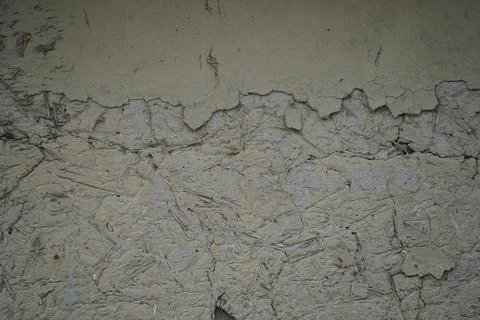 Close up of a weathered mud wall texture with cracks and rough organic surface d Stock Photos