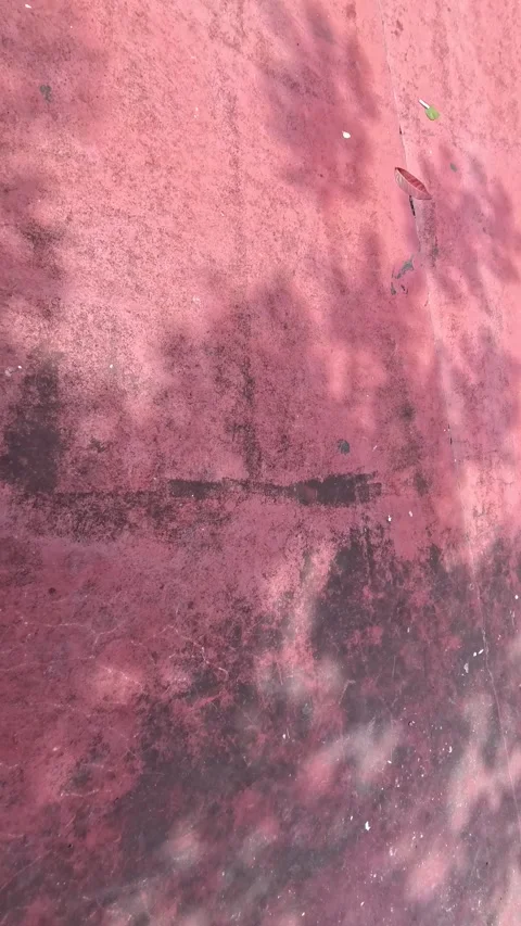 A close-up of a weathered, pink surface with dark, indistinct shadows. Abst.. Stock Footage 305880953