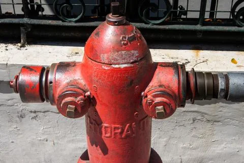 Close up of weathered red fire hydrant top section with valves and hose con.. Stock Photos