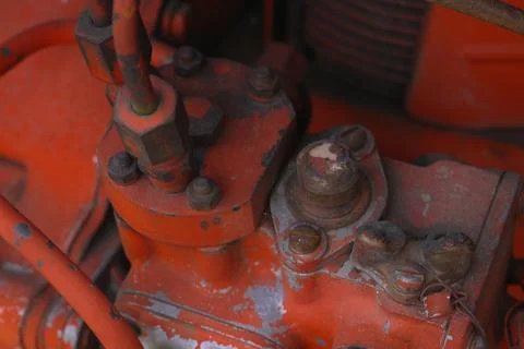 Close Up Weathered Red Tractor Engine Part with Visible Bolts and Nuts Demo.. Stock Photos