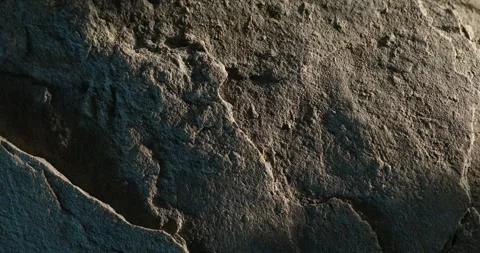 Close-up of weathered rock texture with blue shadow and rough surface detail Stock Footage 312335038