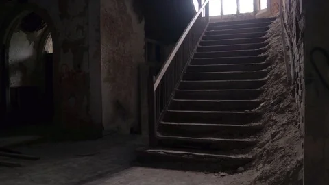 CLOSE UP: Weathered staircase behind stone column in dark room in old cathedral Stock Footage