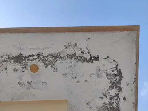 Close up of a weathered wall with peeling paint under a clear blue sky day Stock Photos