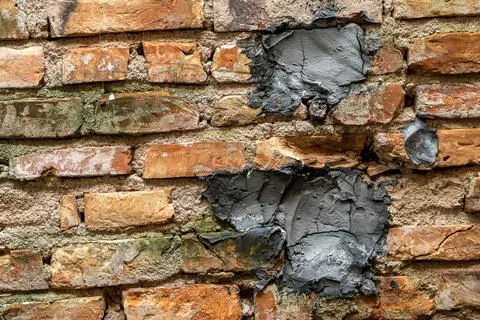 Close-up of a weathered wall with a section of exposed old red bricks Stock Photos