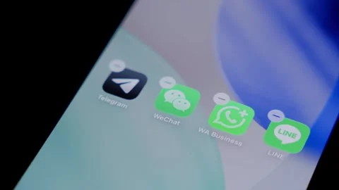 Close-up of the WeChat app being deleted from a smartphone home screen in a Stock Footage 337240811