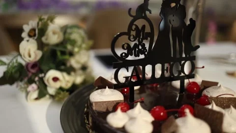 Close-Up Wedding Cake with Decorative Topper and Bouquet on Elegant Table Stock Footage 340560625