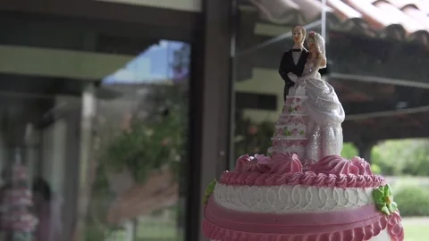 Close-up of a wedding cake with two wedding couple dolls on top Stock Footage 272502896
