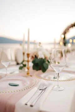 Close-up of wedding dinner table. Beautiful glassware - plates with golden beads 스톡 사진