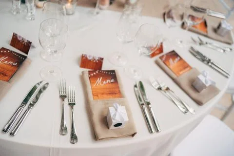 Close-up of a wedding dinner table. Brown napkins with an enclosed menu, forks 스톡 사진
