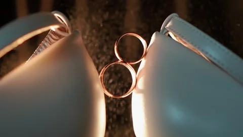 Close-up of the wedding rings of the bride and groom before the outdoor ceremony Видео 261880609