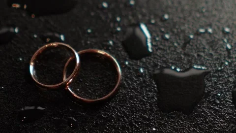 Close-up of the wedding rings of the bride and groom before the outdoor ceremony Видео 264784848
