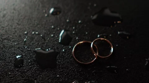 Close-up of the wedding rings of the bride and groom before the outdoor ceremony Видео 264784862