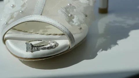 Close up wedding rings on tip of wedding shoes Stock Footage 170374135