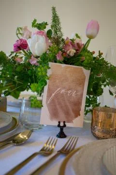 Close up of wedding table set decorated with fresh flowers. Stock Photos